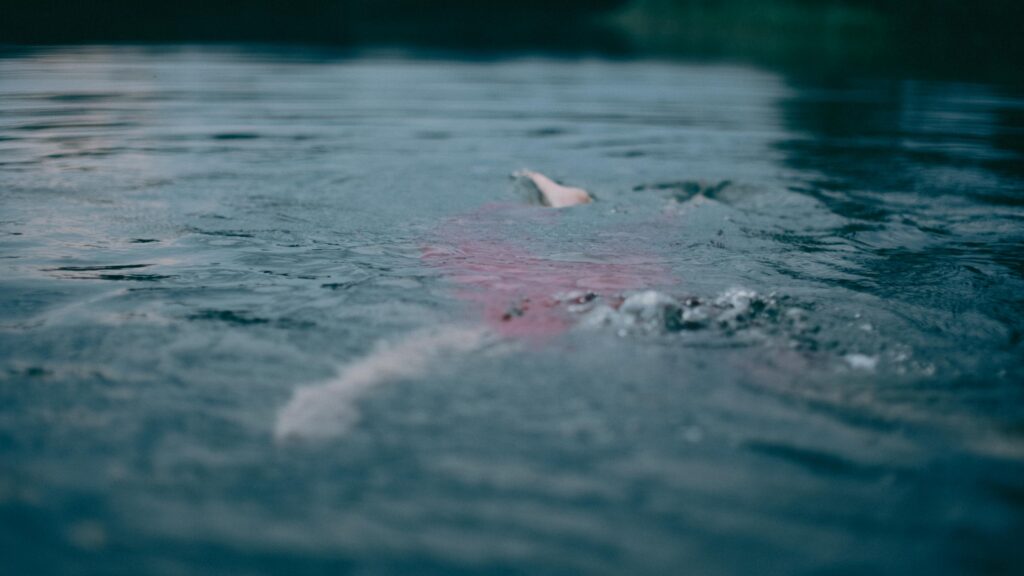 Person schwimmt im ruhigen Wasser
