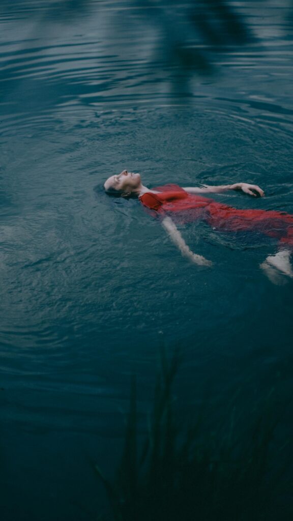 Frau schwimmt in stillem Wasser.