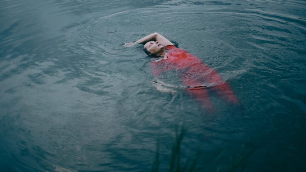 Frau in rotem Kleid im Wasser