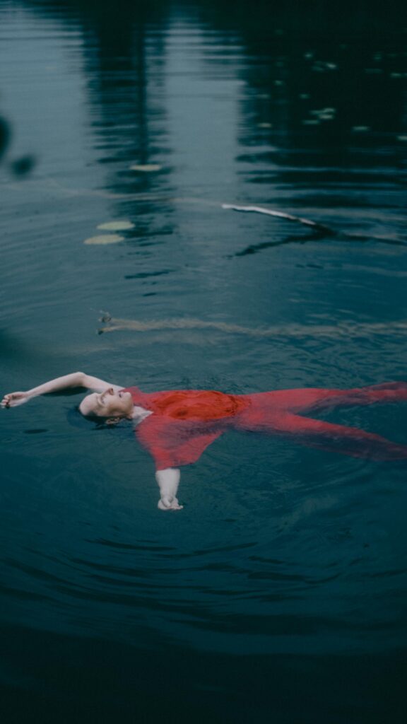 Frau in rotem Kleid schwimmt