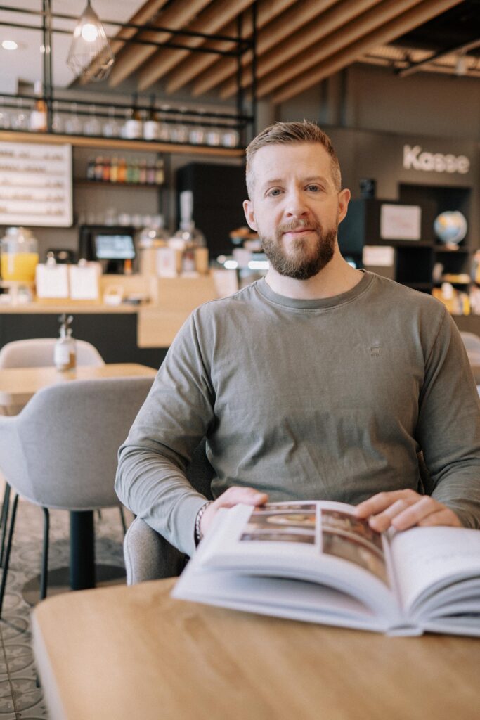 Mann liest in einem Café.