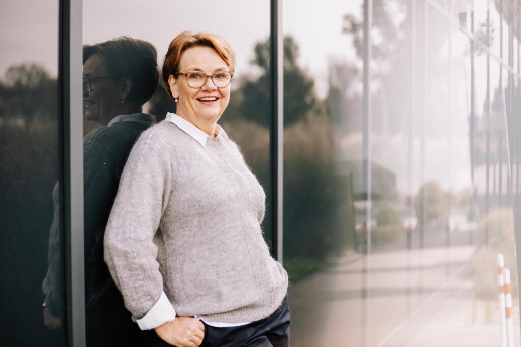 Lächelnde Frau vor Glaswand